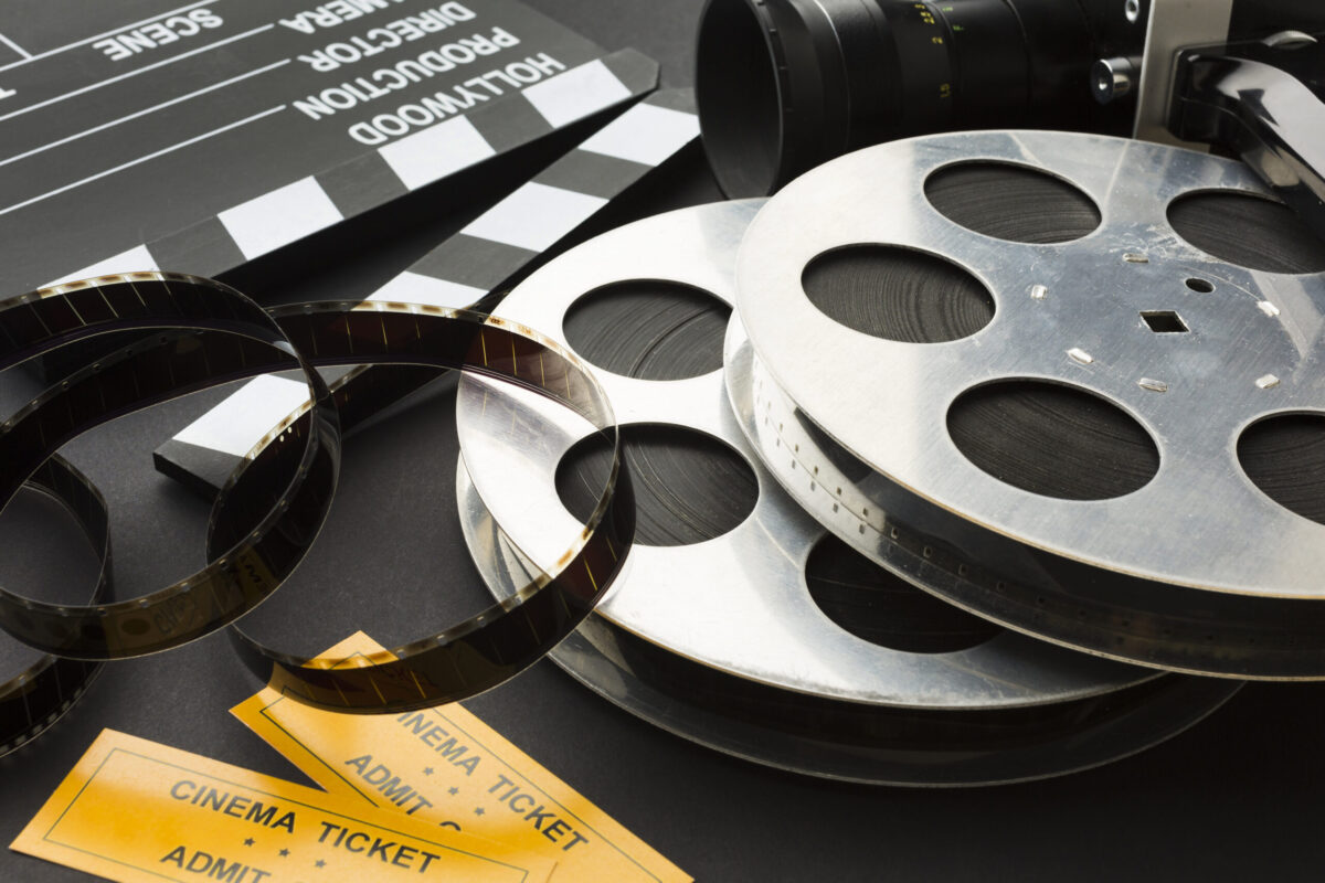 Régi filmes tekercsek, vágócsapó és mozijegyek egy filmes blogcikk illusztrációjához